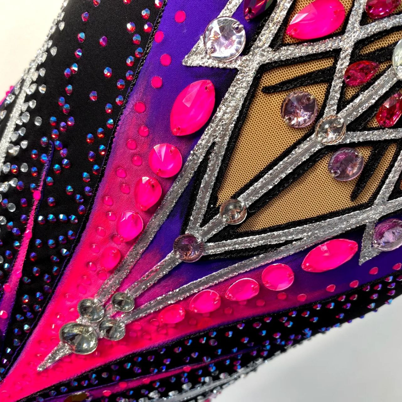 Melody An elegant original leotard for performances and competitions in black, neon pink, purple colors with silver patterns, sleeveless, with a skirt - will perfectly complement the image of a gymnast and will stand out and shine brightly on stage